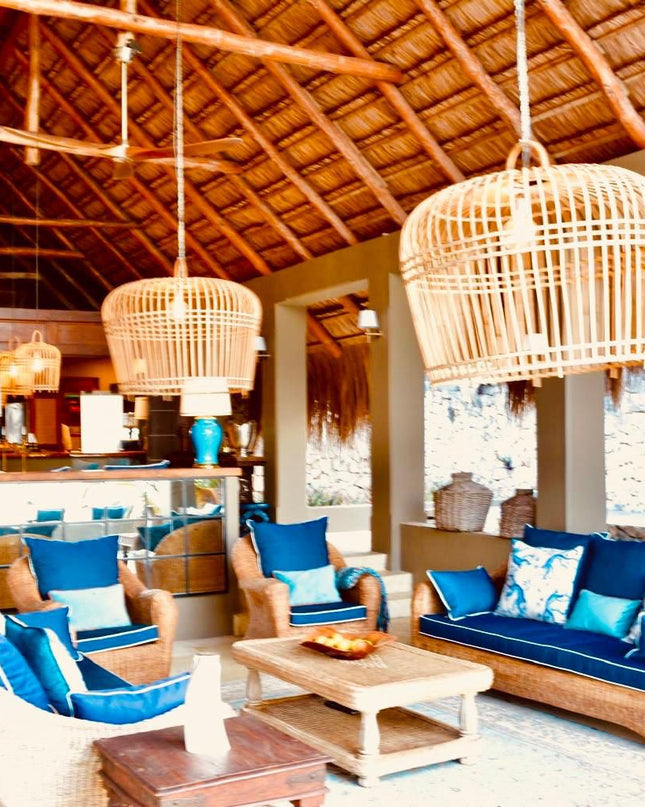 Modern living room with blue cushions on furniture, wooden ceiling, and decorative lamps.
