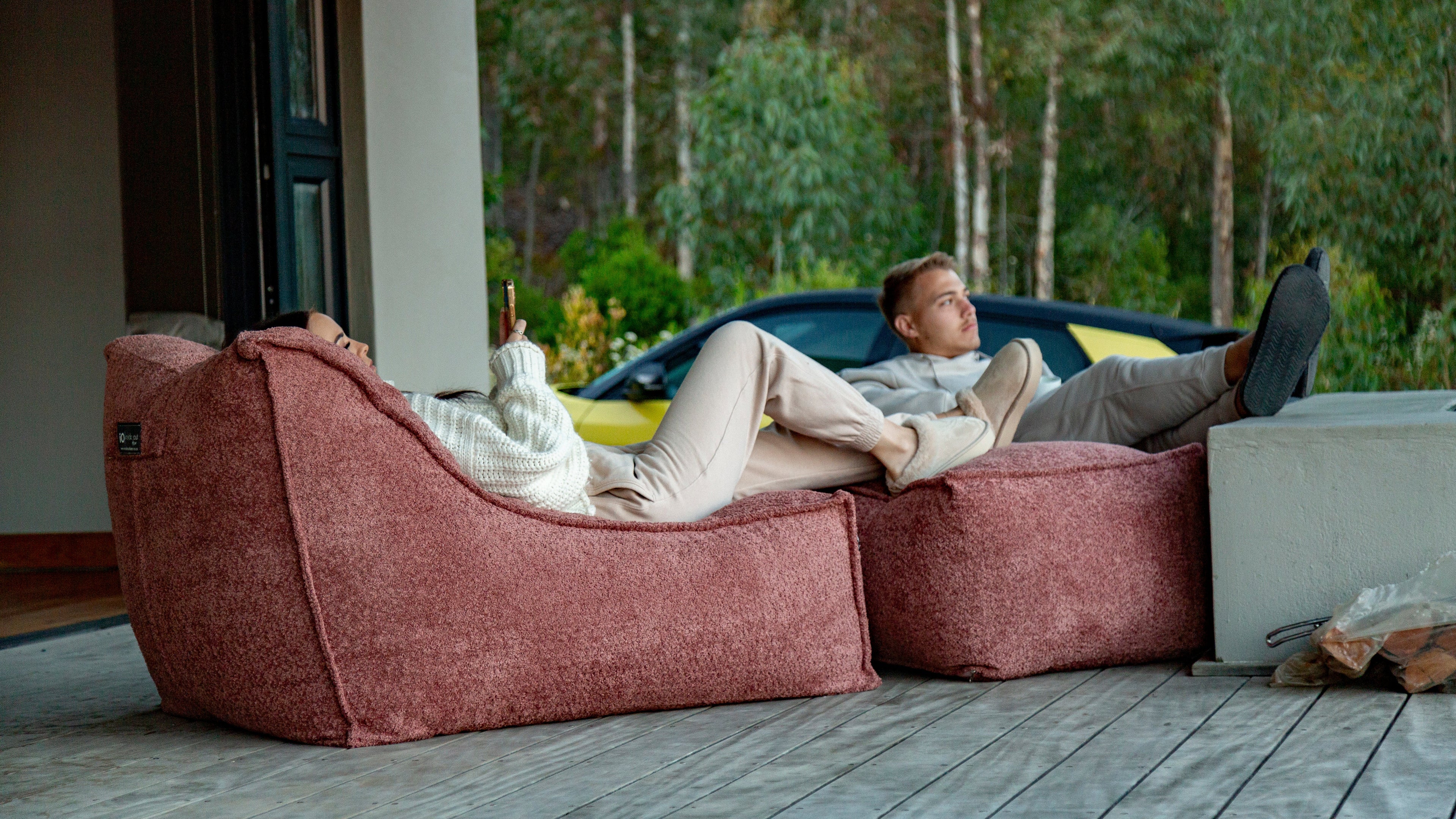 Person relaxing on a large bean bag chair with a scenic view outside